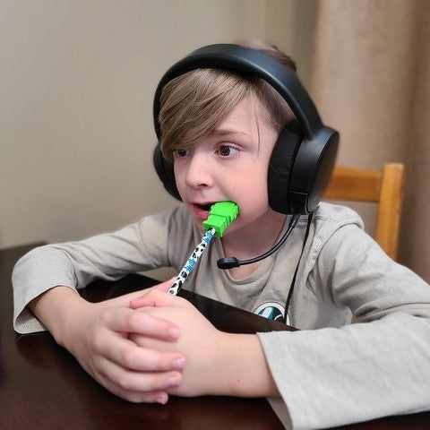 Young kid chews on chewable pencil topper