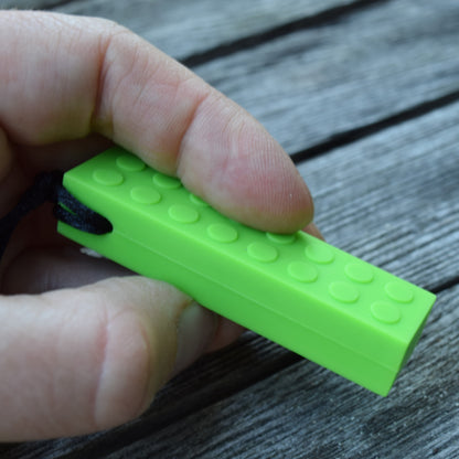 Munchables LEGO-like chewable necklace held in fingers for scale.