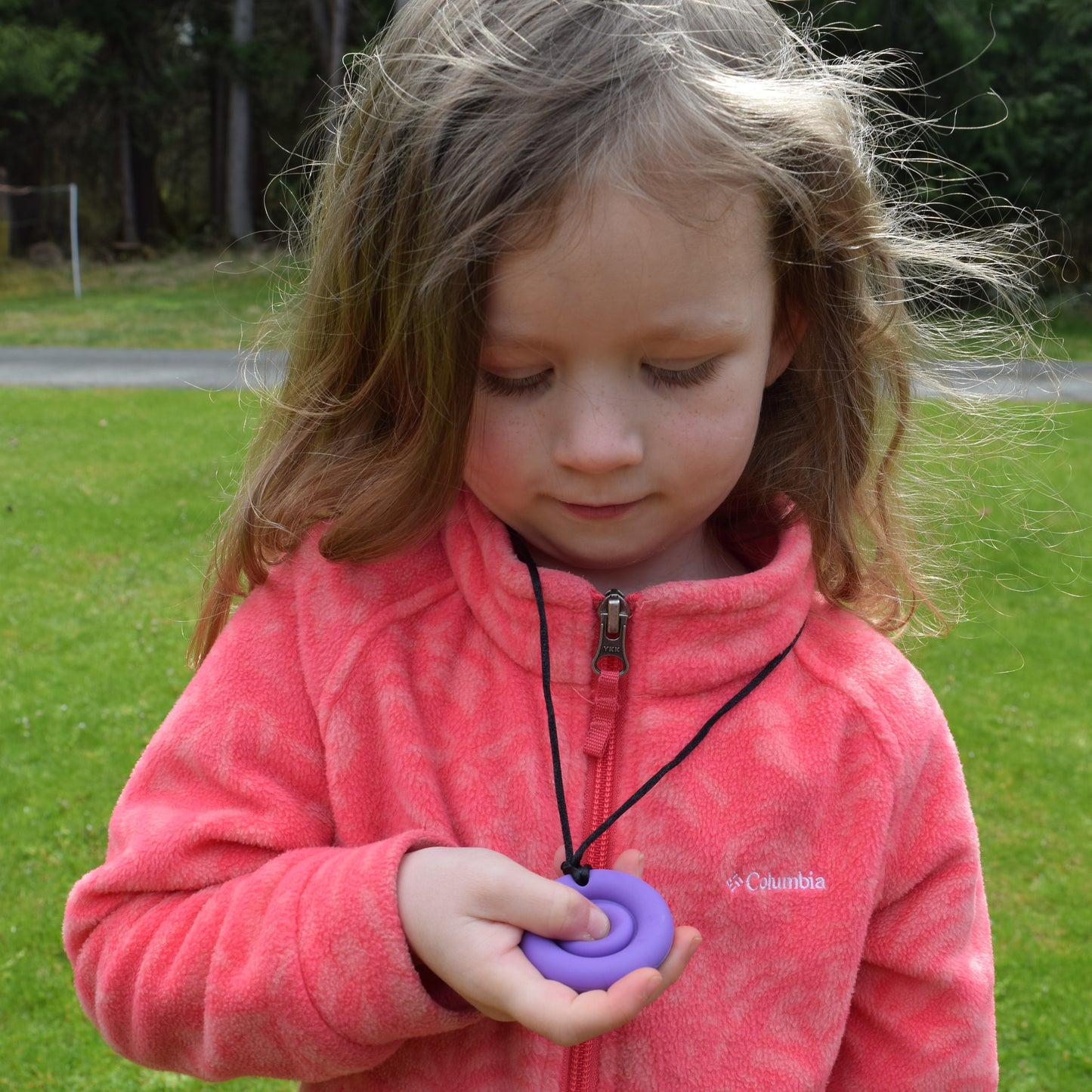 Girl playing with Munchables Pop It Bubble Popper Fidget Chew Necklace