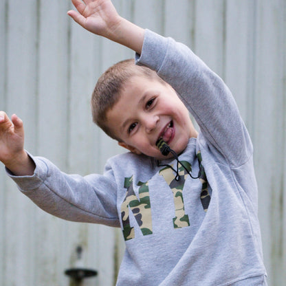 Boy chews on green camo chewelry while dancing