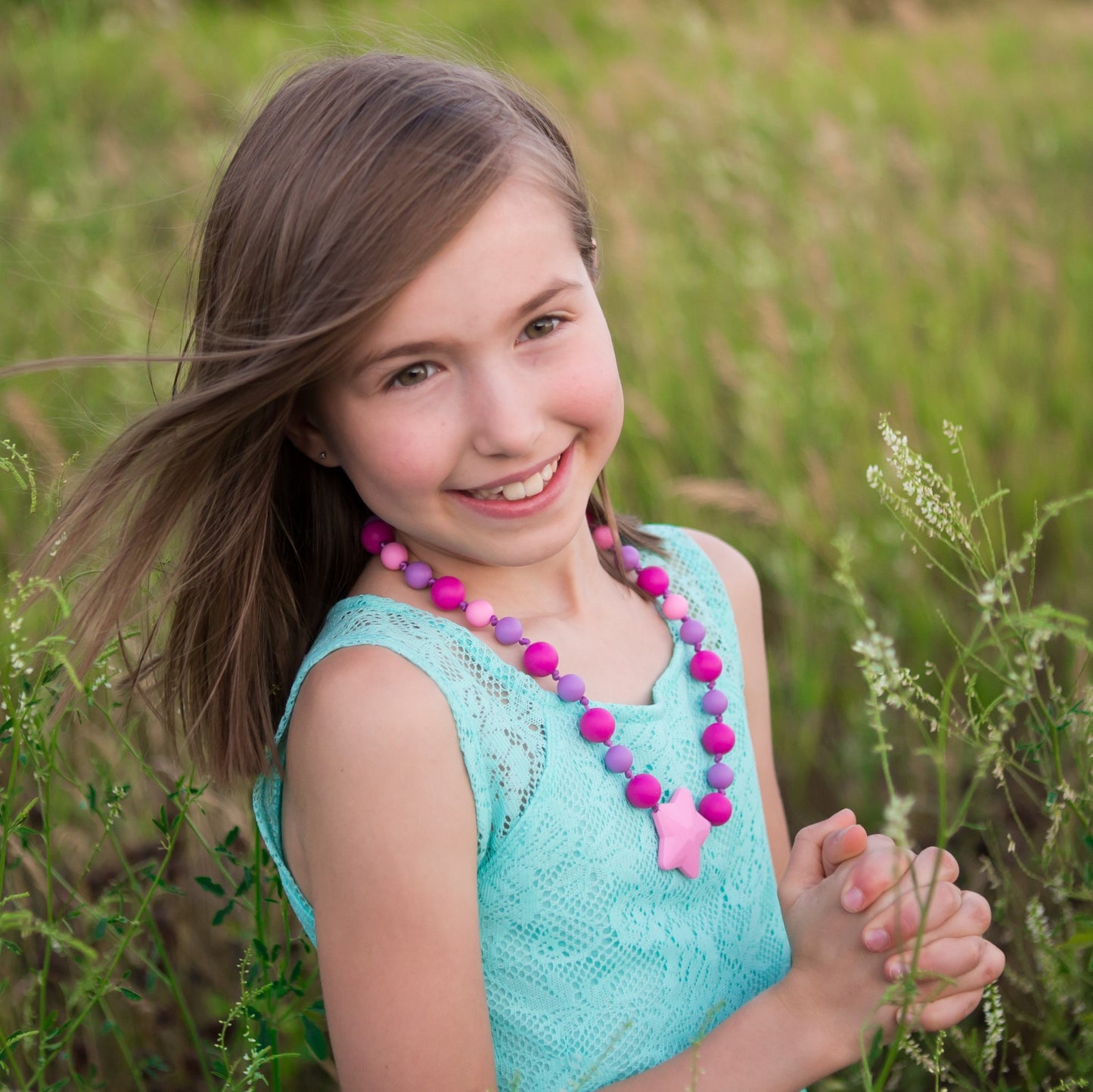 Young girl wearing Munchables Starlight Chew Necklace.